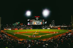 Exciting evening baseball game with fans at AT&T Park stadium under bright lights.